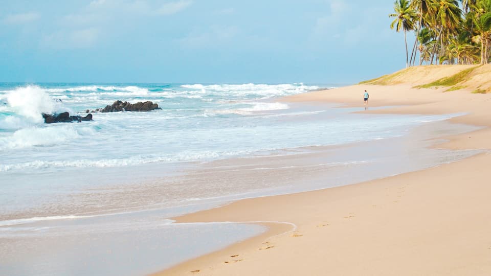 Man walking alone along Stella Maris beach in Salvador city, Brazil. September, 2011.