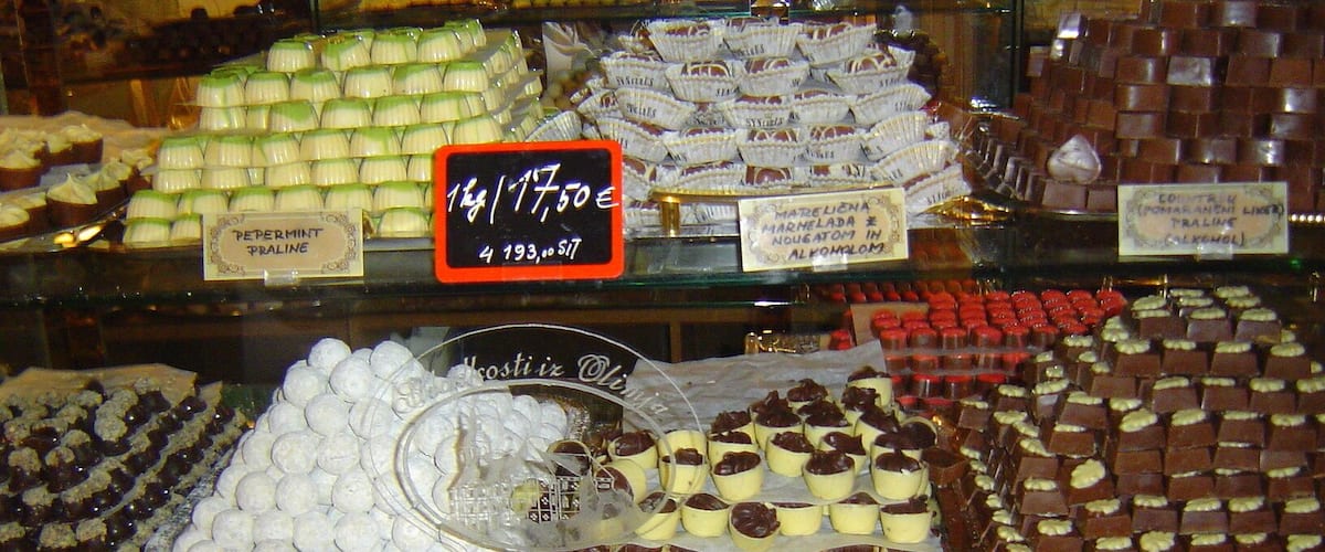 A variety of sweets displayed in a glass case, including pralines, chocolates, and other confections.