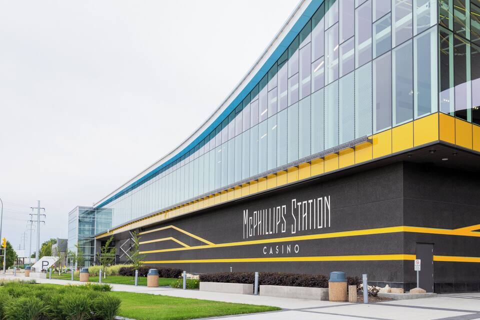 Un edificio moderno con amplios ventanales y un llamativo letrero que dice 'McPhillips Station Casino'.