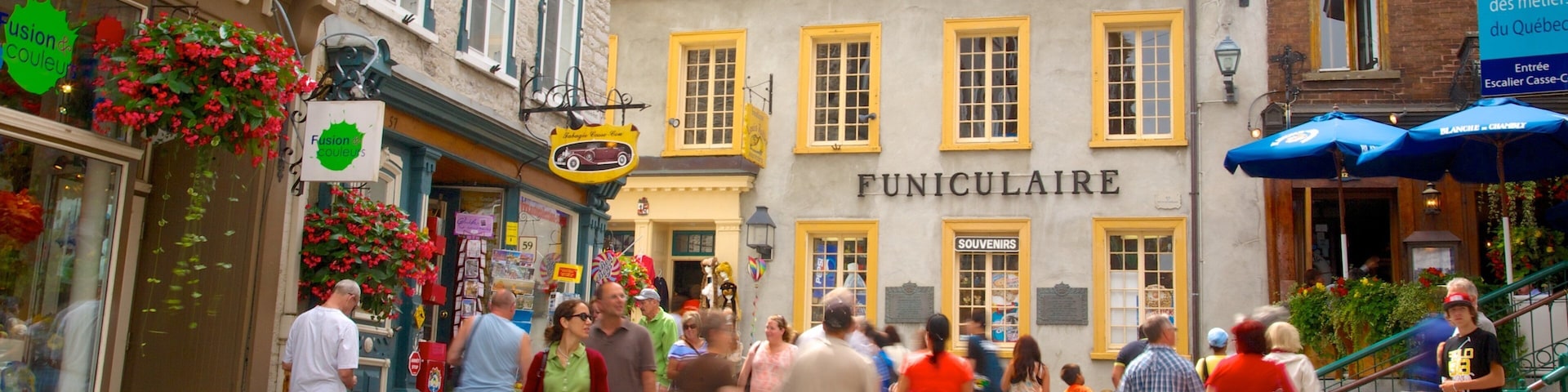 A bustling street with people walking, a building labeled "FUNICULAIRE," and shops with colorful signs.