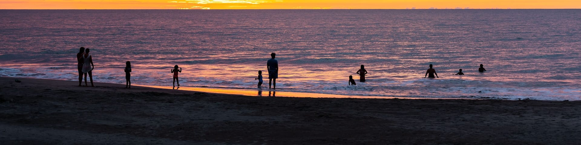 People silhouettes swimming in Pacific Ocean on Same beach between Atacames and Sua, Esmeraldas province, Ecuador.