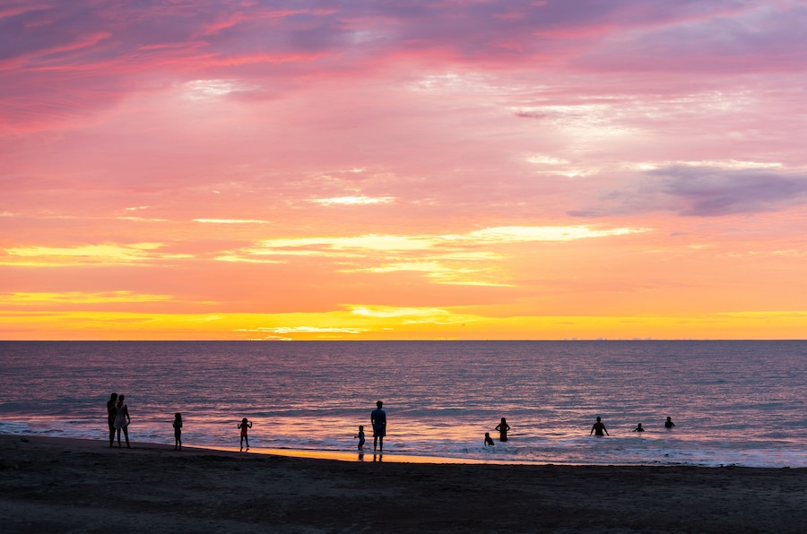 People silhouettes swimming in Pacific Ocean on Same beach between Atacames and Sua, Esmeraldas province, Ecuador.