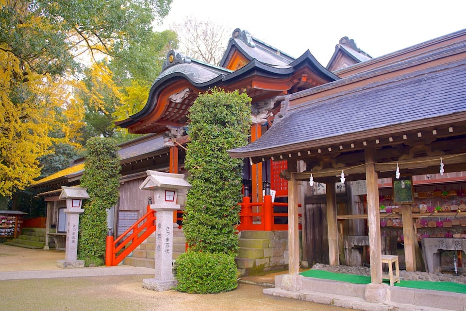 A traditional Japanese building with a tiled roof, red accents, and a stone staircase.