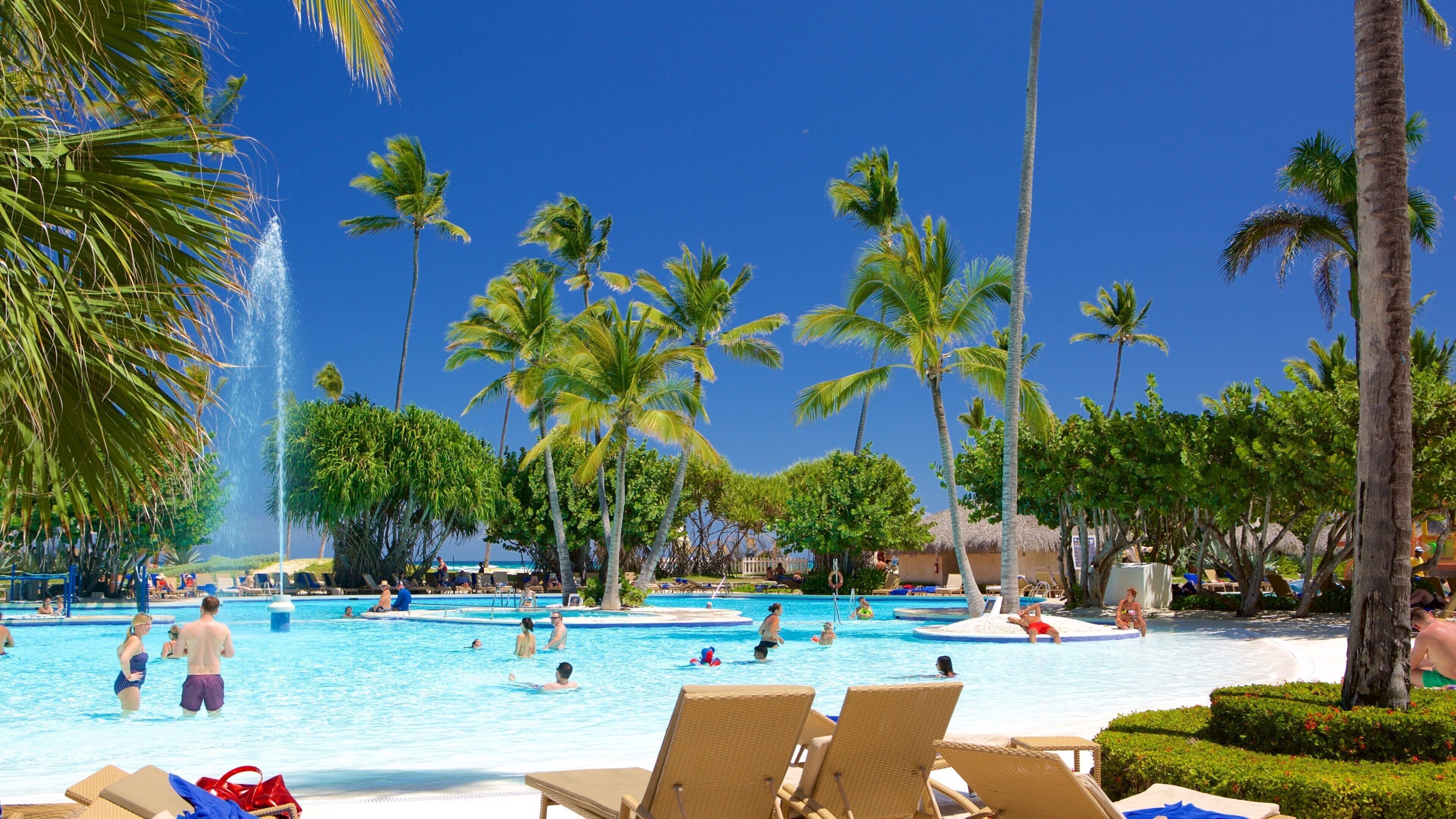 Arena Gorda Beach showing tropical scenes and a pool as well as a small group of people
