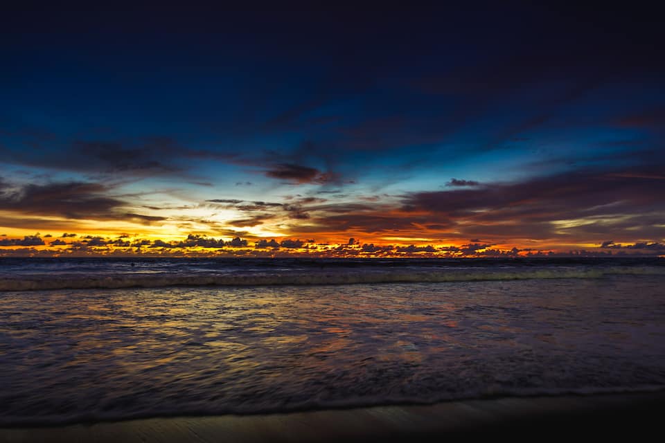 A sunset over a beach with waves.