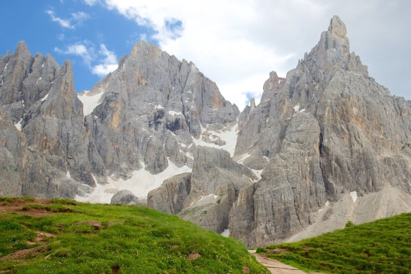 A mountain range with sharp peaks and patches of snow.