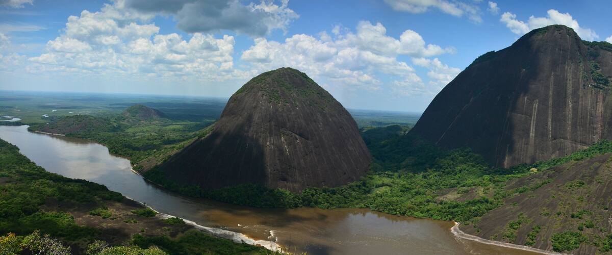 A river winding through a lush landscape with two prominent mountains.