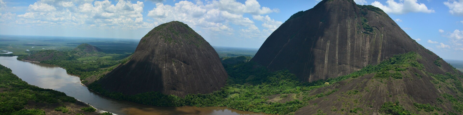 A river winding through a lush landscape with two prominent mountains.