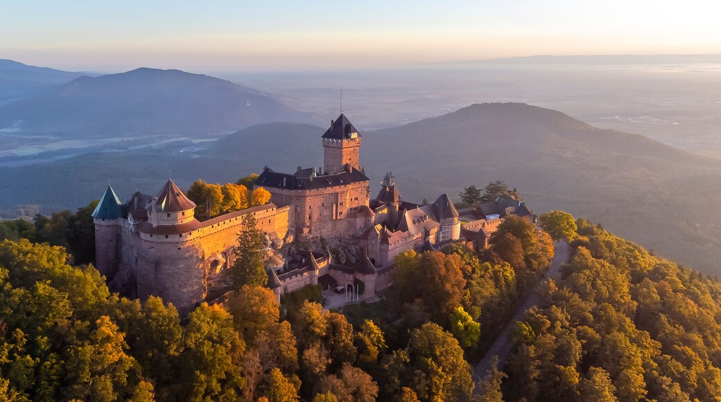 Un château historique entouré de collines boisées.