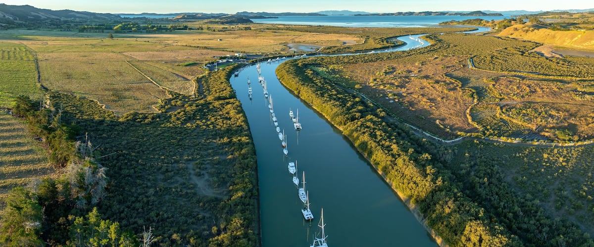 A river winding through a landscape with boats docked along the banks.