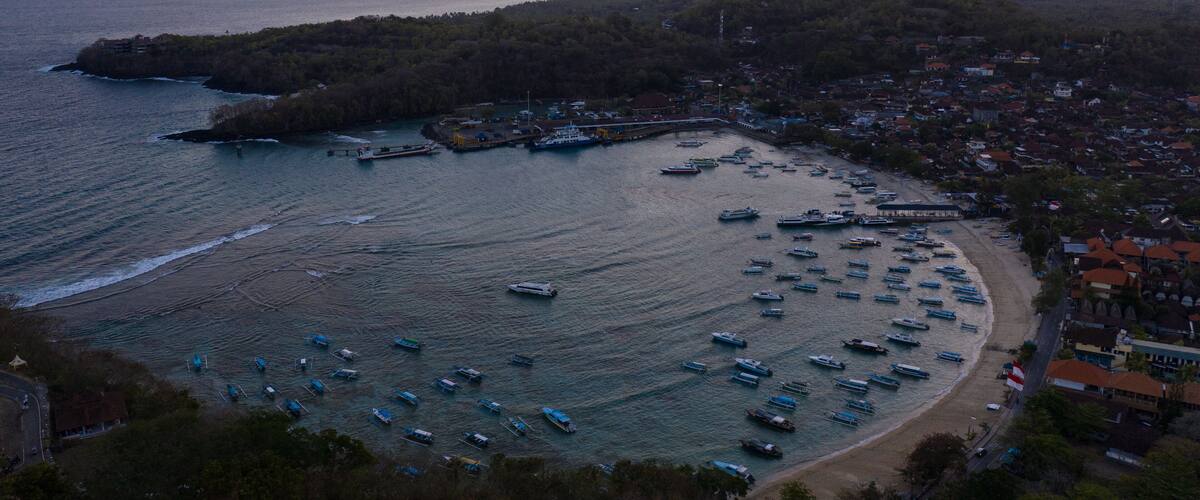 Aerial view of the sunset over the stunning Padangbai bay, beach and ferry harbor in Bali, Indonesia