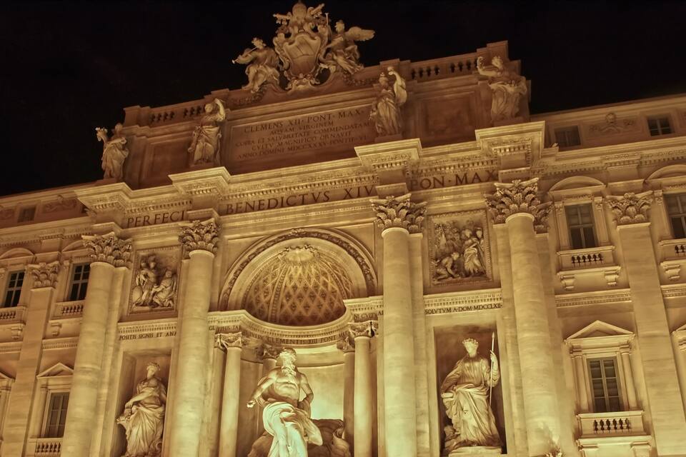 A grand building with classical architecture, featuring columns, statues, and intricate carvings.