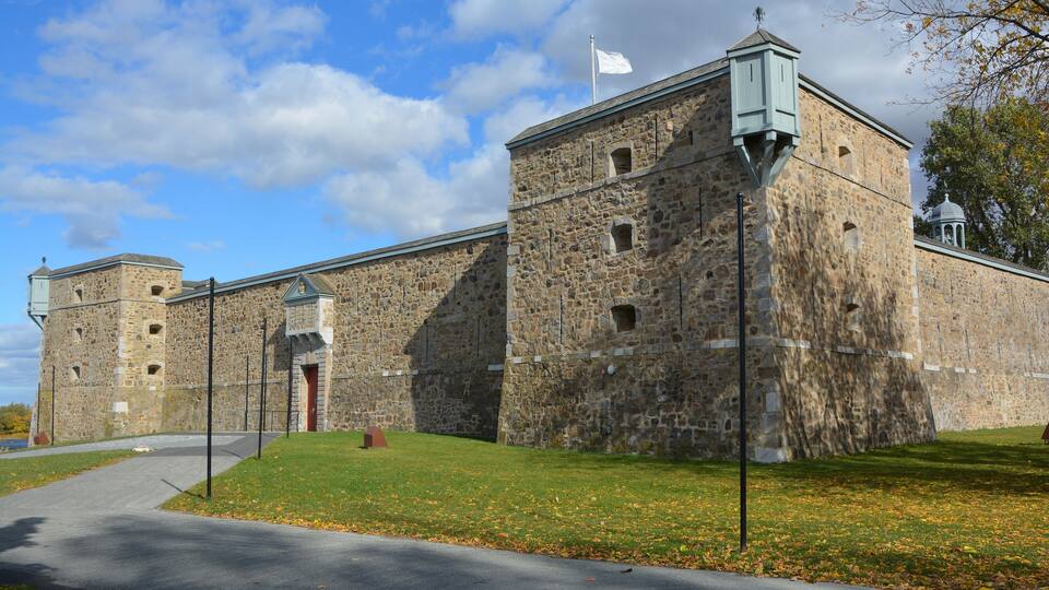 A historic stone building with a flagpole and a small tower.