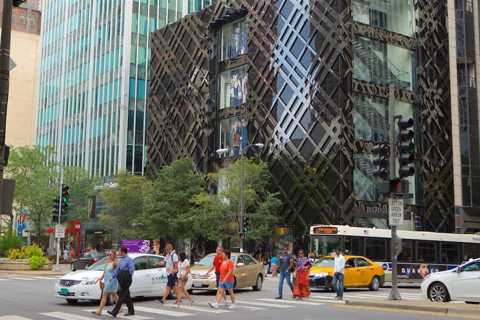 A busy urban street with pedestrians, cars, and a distinctive building with a geometric facade.