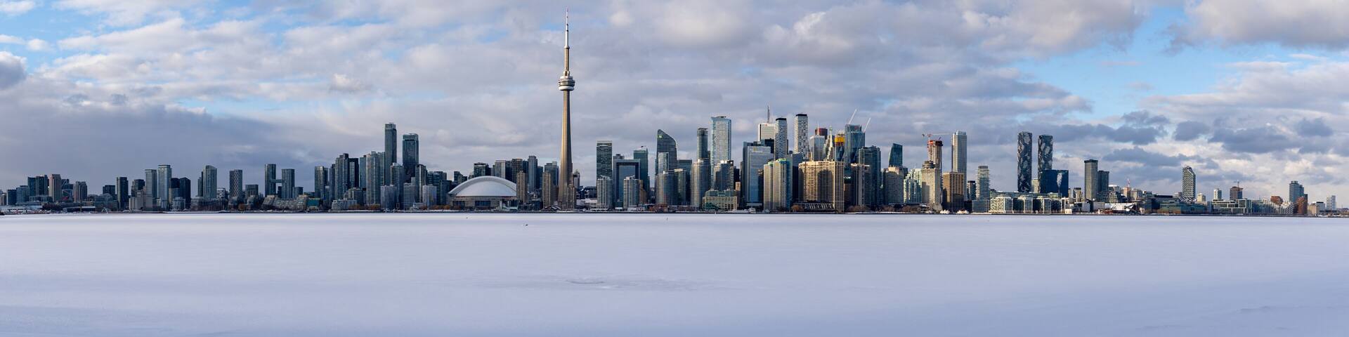 A city skyline with a prominent tower and a dome-shaped building amidst a snowy landscape.