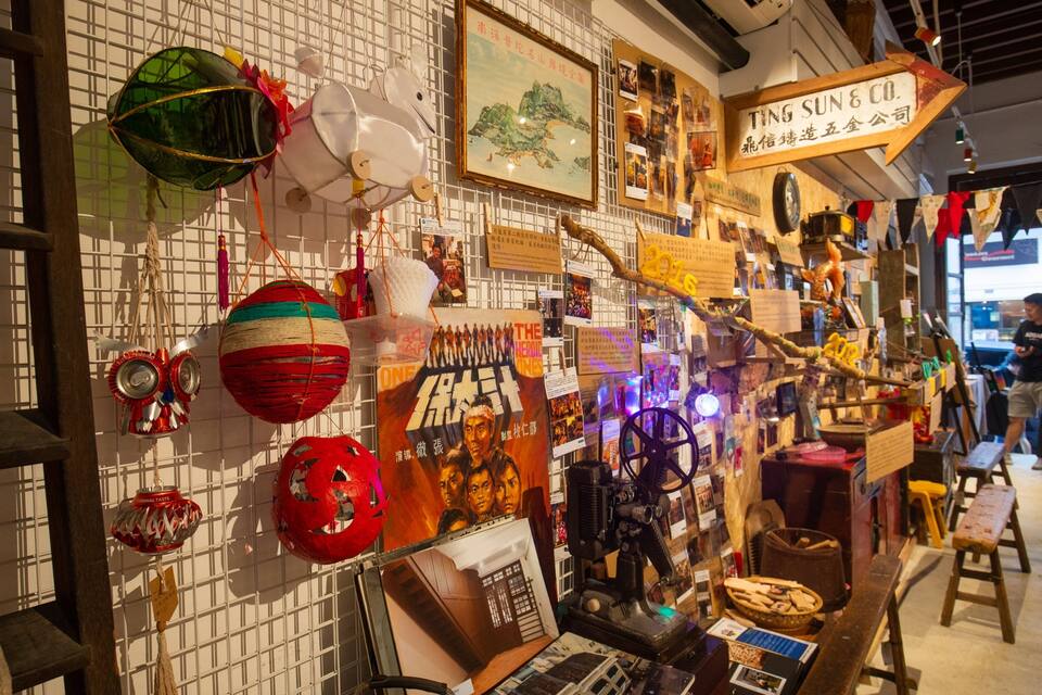 Een muur versierd met diverse objecten, waaronder een klok, een lijst met foto en verschillende decoratieve hangers.