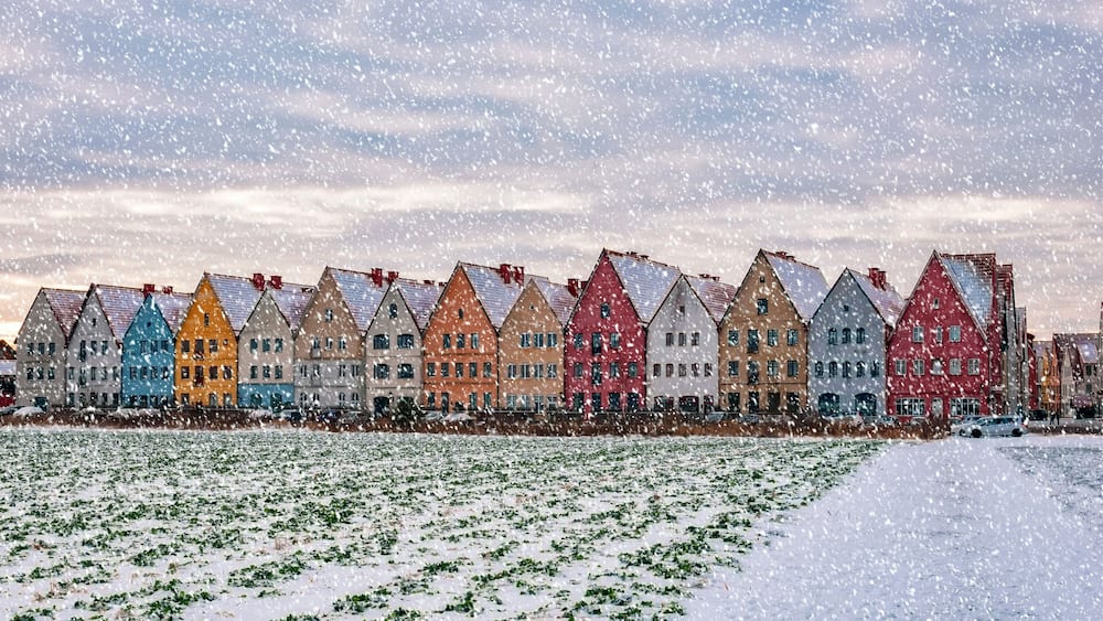 A row of colorful houses with snow on the ground.
