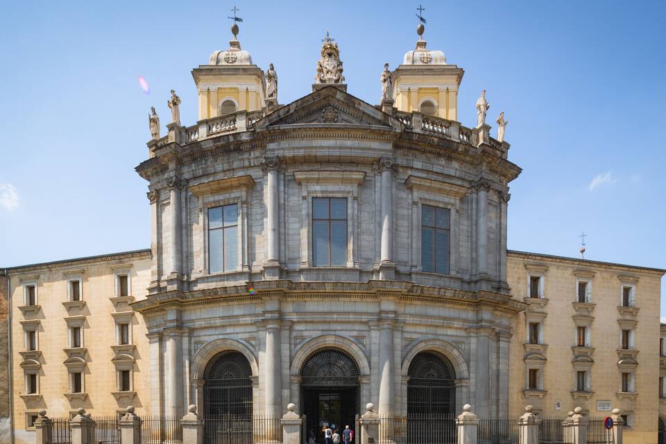 Un edificio histórico con una cúpula central, ventanas en arco y estatuas en el techo.