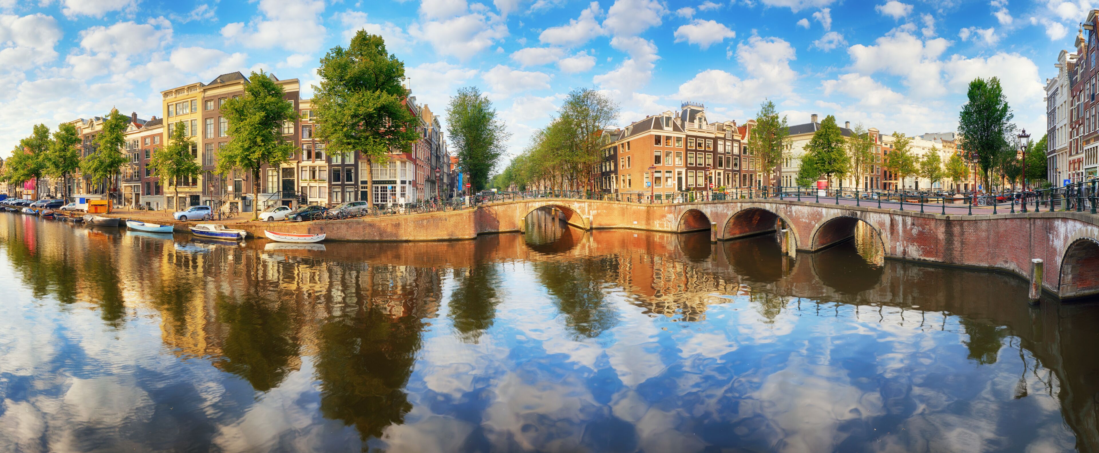 Un canal con un puente, edificios históricos y barcos.