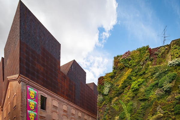 A building with a rust-colored facade and a large billboard featuring Warhol's Marilyn Monroe.