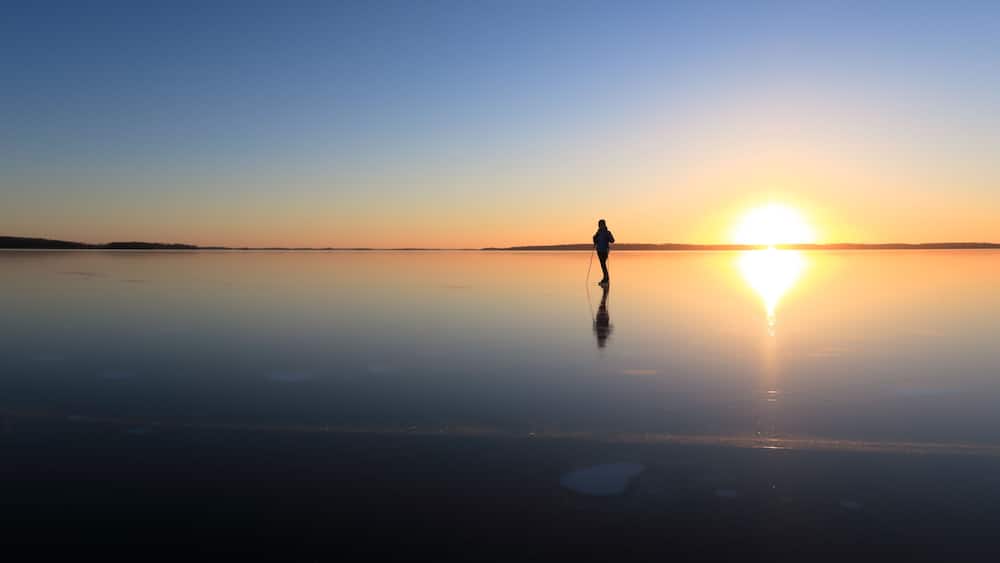 Ice skating on lake Malaren, Sweden, at sunset.