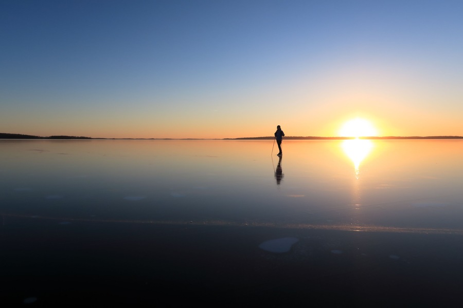 Ice skating on lake Malaren, Sweden, at sunset.