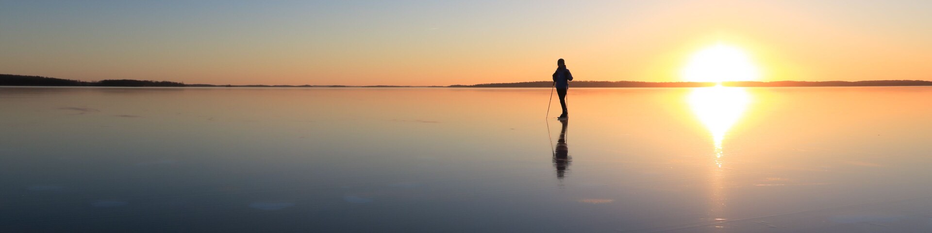 Ice skating on lake Malaren, Sweden, at sunset.