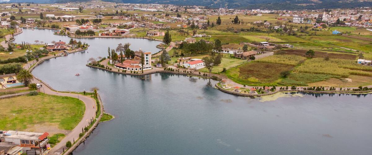 A river winding through a town with buildings and greenery.