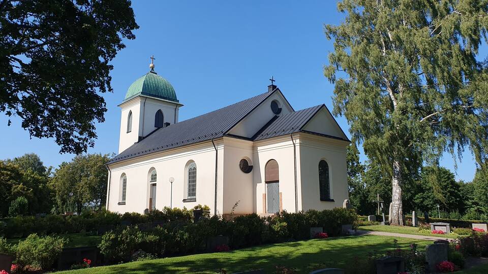 A church with a green dome and a bell tower.
