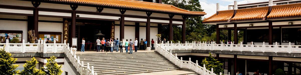 A traditional building with a tiled roof, a staircase, and a white fence.