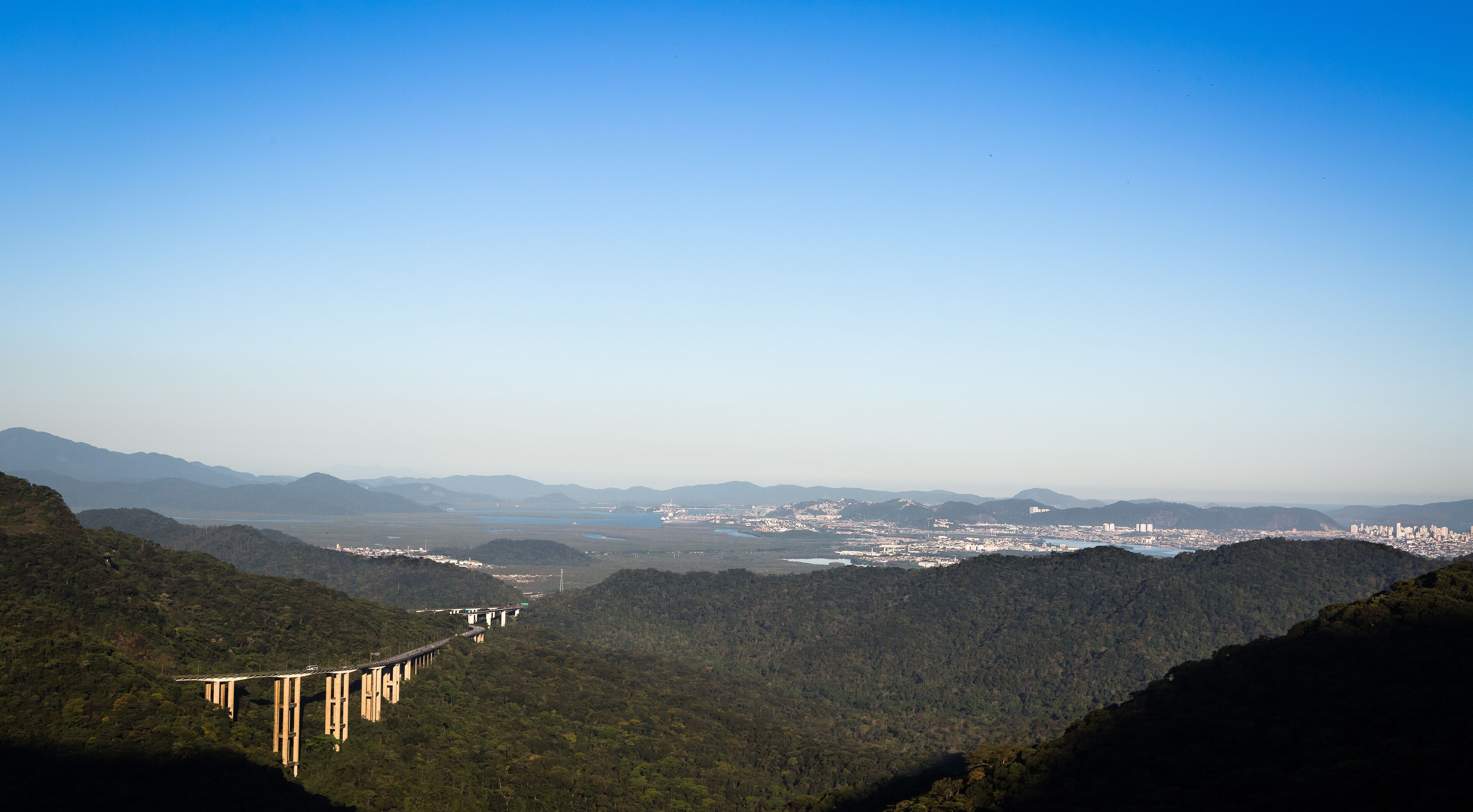 View from the top of Serra do Mar with the Imigrantes Highway highlighted and in the background the city of Santos, São Vicente, Brazil.