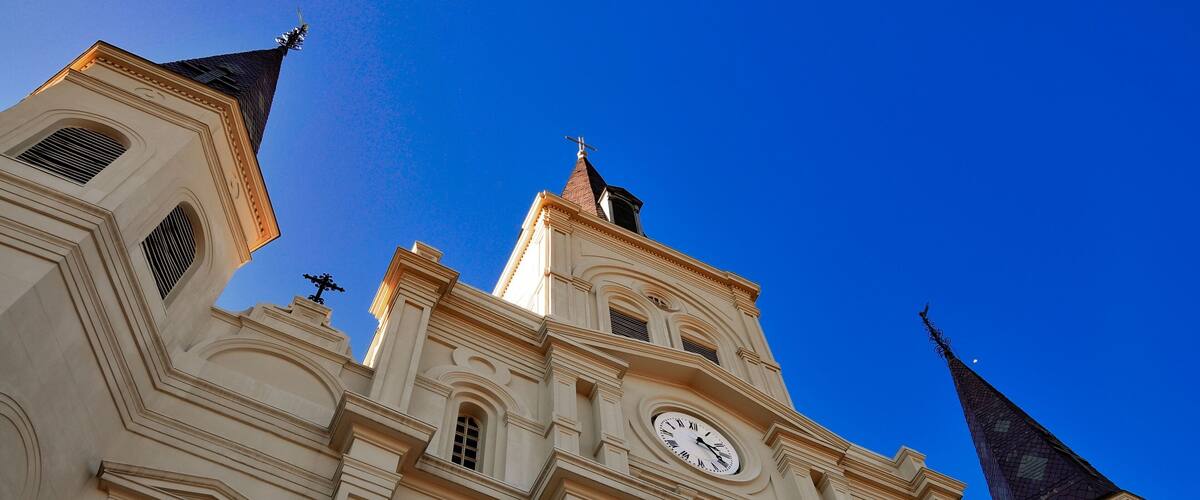 Low-angle view of St. Louis Catherdral in New Orleans, Louisiana, with a blue sky in the background
