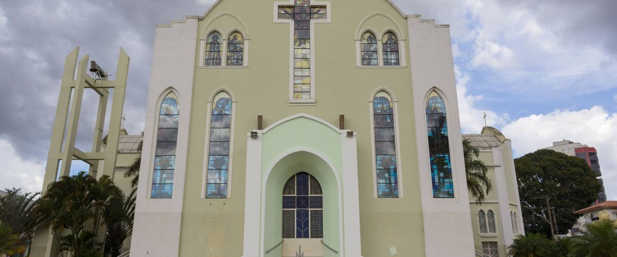 A church with a large cross, arched windows, and a bell tower.