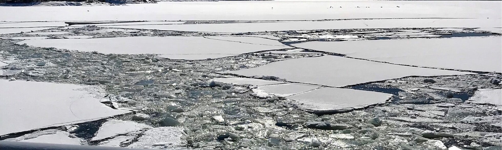 A frozen lake with ice floes and a clear sky.