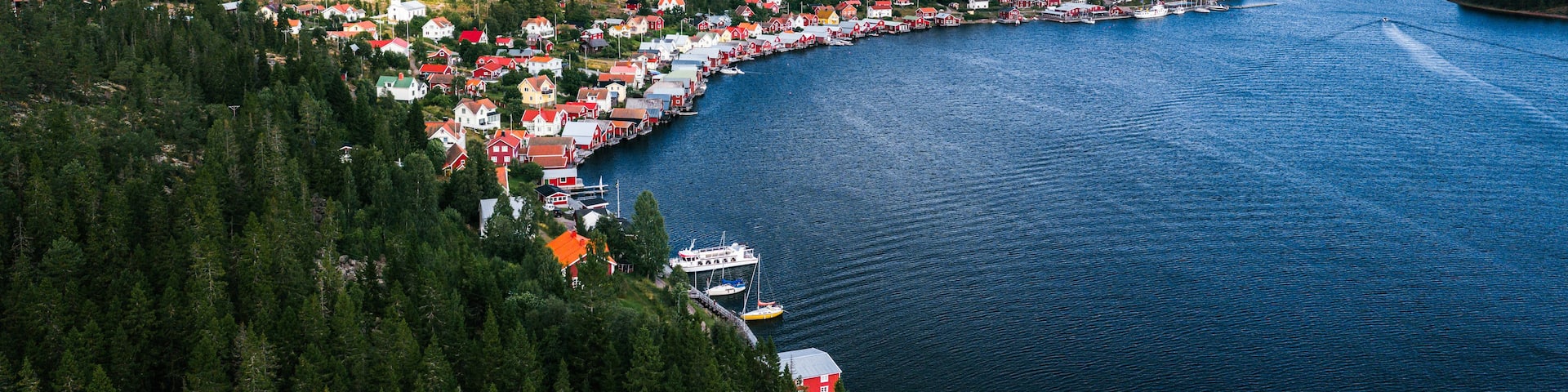 A coastal town with red-roofed houses, a church, and a body of water.