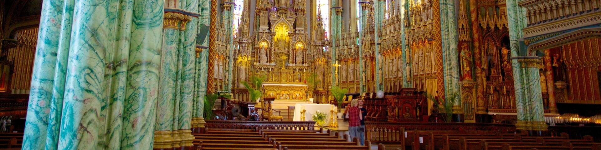 An ornate church interior with marble columns, vaulted ceilings, and a central altar.