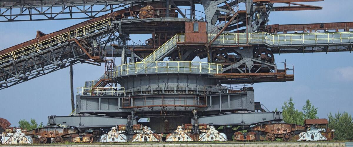 A large industrial mining structure with multiple conveyor belts and a central control tower.
