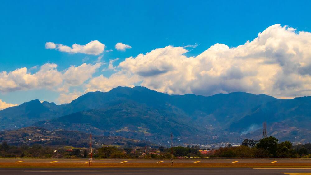 A mountainous landscape with a clear sky and a runway in the foreground.