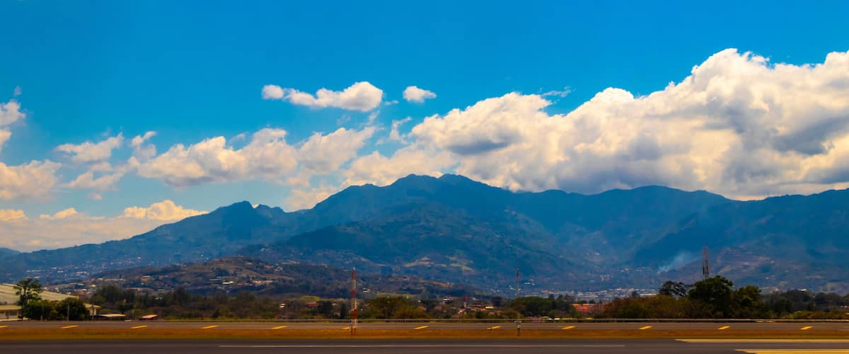 A mountainous landscape with a clear sky and a runway in the foreground.