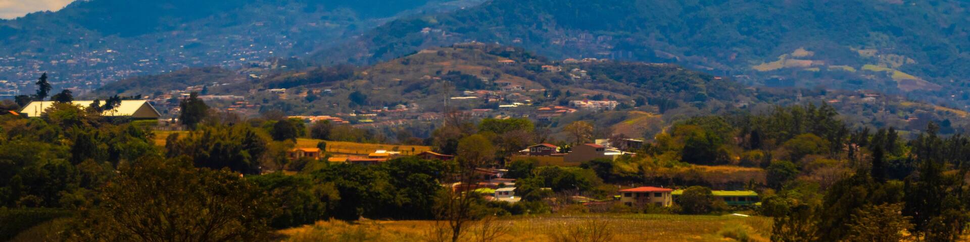 Runway airport city mountains panorama view from airplane Costa Rica.