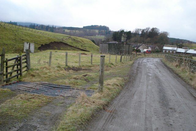 Bent Cattle Grid alongside Farm Road The road runs south-east up the valley of the Longcote Burn from Eddlestone (seen in the background) to Burnhead Farm.