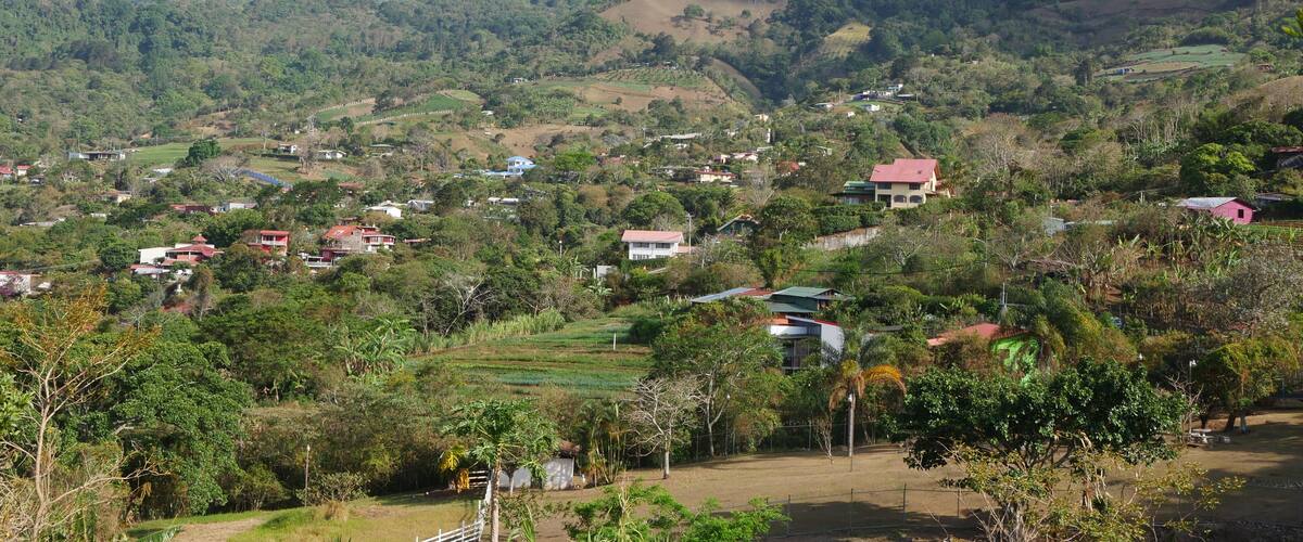 A mountainous landscape with scattered houses and lush greenery.