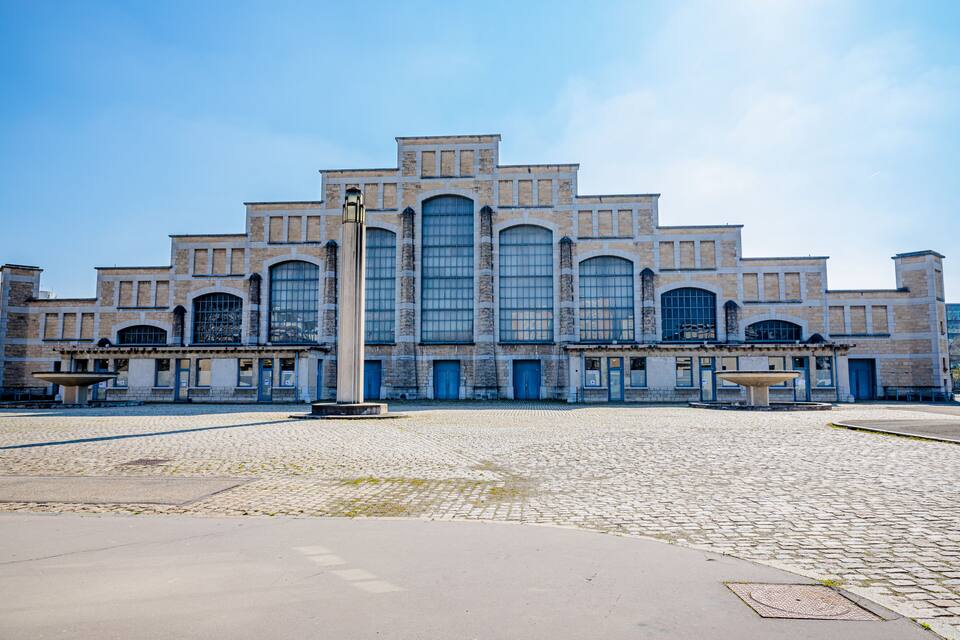 Un grand bâtiment historique doté d’une tour centrale et de nombreuses fenêtres en arc.