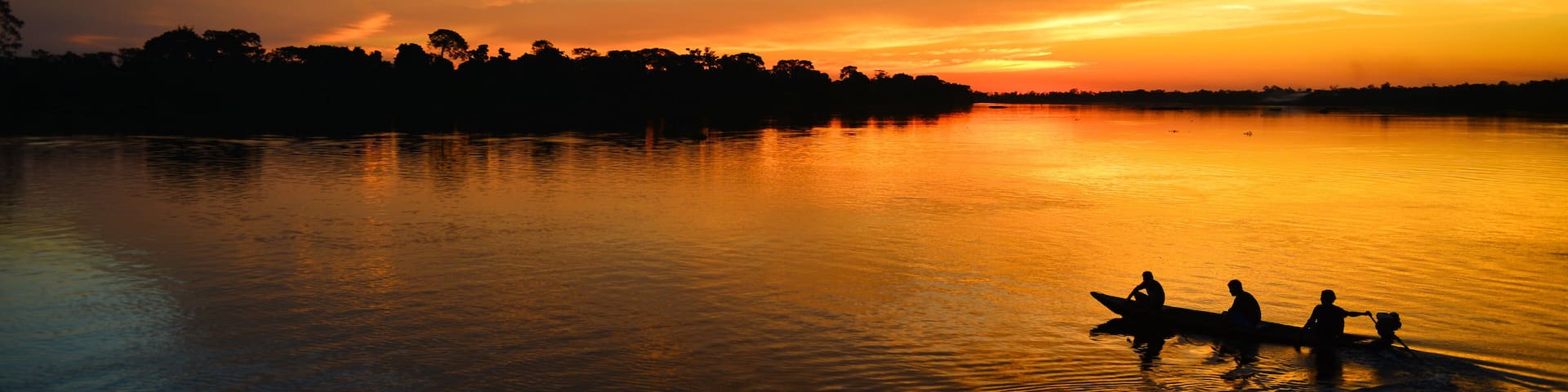 A small motorized canoe on the Guaporé - Itenez river during sunset, Ricardo Franco village, Vale do Guaporé Indigenous Land, Rondonia, Brazil, on the border with Bolivia