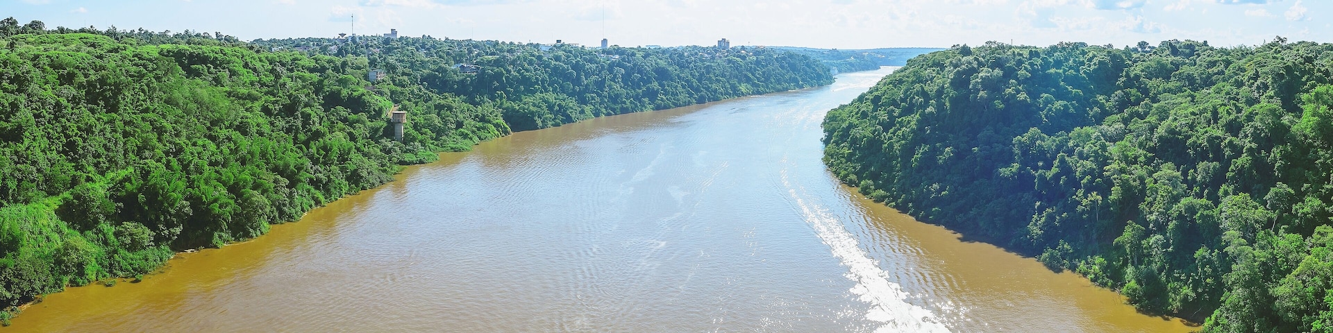 Panoramic photo taken over the Tancredo Neves bridge from the Iguacu river and the borders from Brazil and Argentina. On the right side is Brazil, on the left is Argentina.