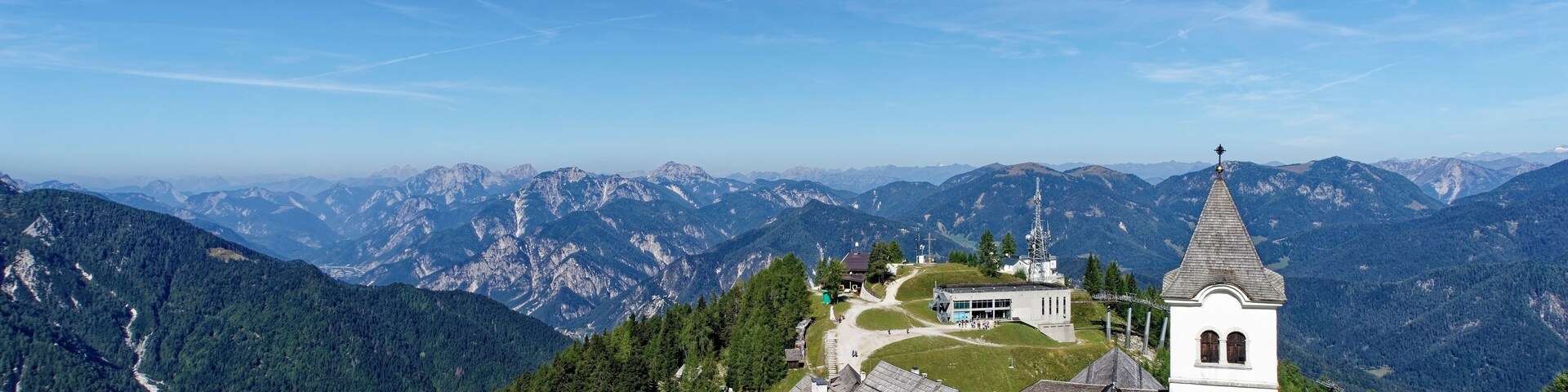 Un pueblo de montaña con casas tradicionales, una iglesia y un campanario.