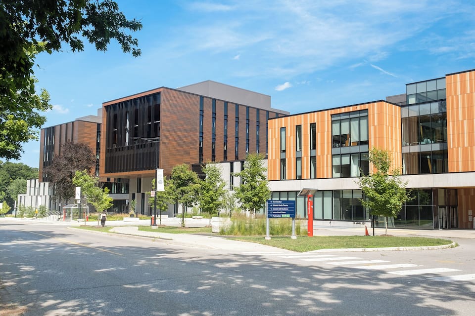 A modern building complex with large windows and wooden paneling.