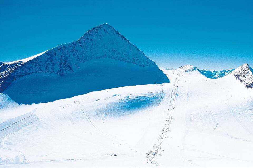 A snow-covered mountain peak with a clear sky.