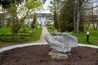 A sculpture, a remnant of an old building long since demolished, sits in the center of a large flower pot in the Guild Inn's Garden of Ruins in Scarborough (Toronto), Ontario.