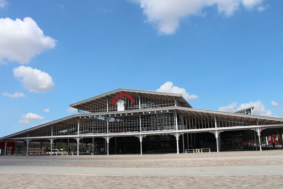 Een groot, historisch treinstation met een opvallende klokkentoren en overdekte gangpaden.